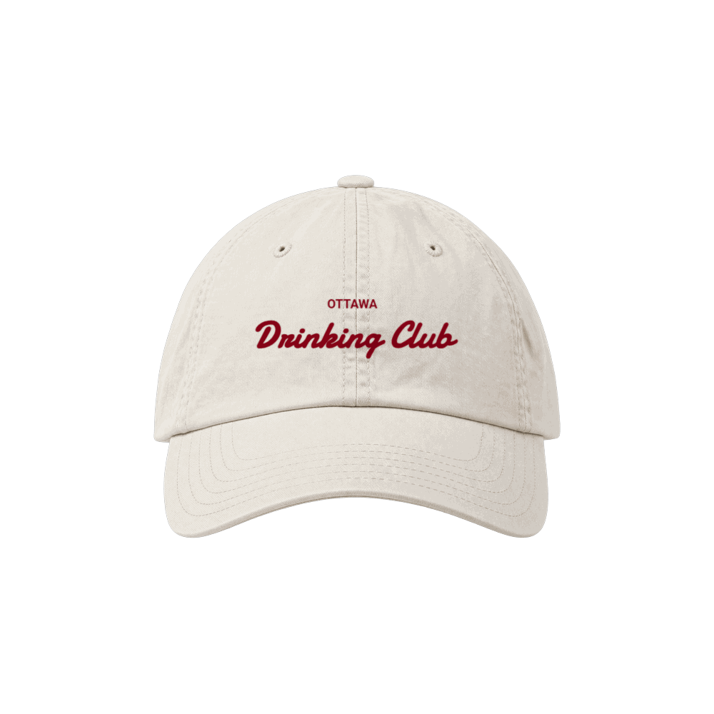 Cream dad hat with a curved brim and the Ottawa Drinking Club script wordmark embroidered on the front, photographed on a plain ground